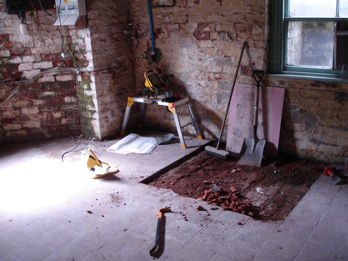 Exploratory hole in basement floor. We're trying to keep the tiles for a new patio.