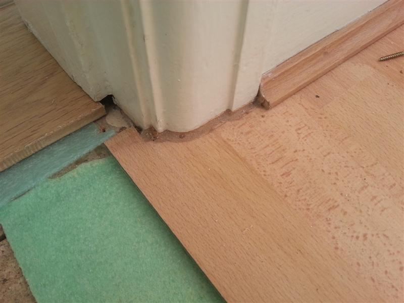 This laminate flooring was cut around the door frame and then filled with a flexible coloured sealant, sometimes called a dirt magnet or a complete mess..