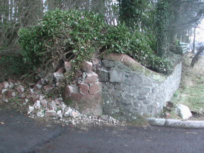 The collapsed pillar and damaged wall before work started.