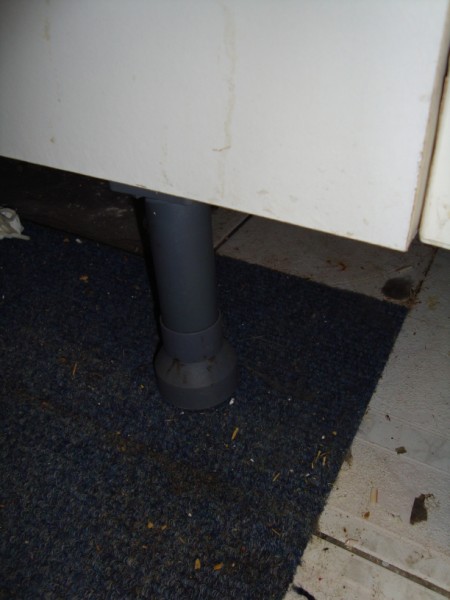 Picture showing grey plastic leg supporting base unit - can this be unscrewed/ moved to remove carpet tile/ install vinyl without cutting round?